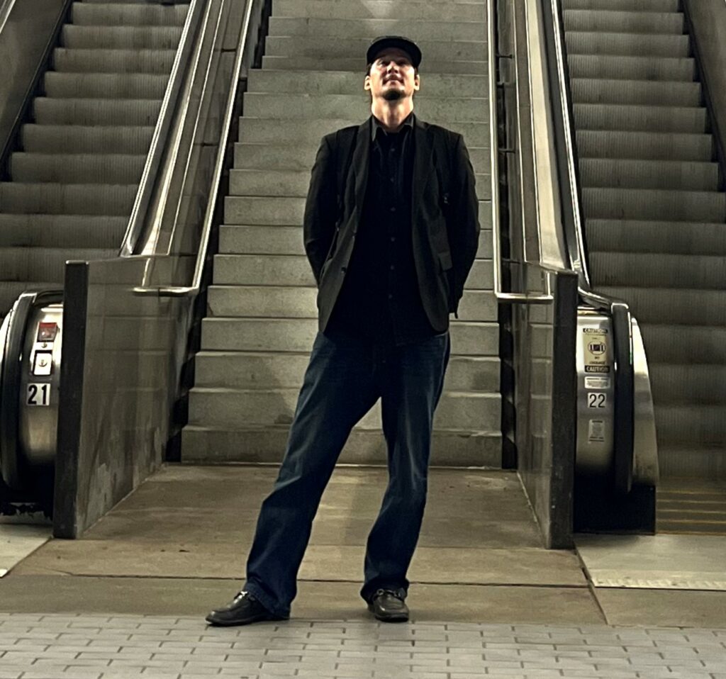 Photo of Andy Trench standing in front of two escalators and a set of stairs